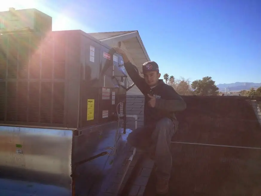 HVAC technician performing AC Tune-Up on a rooftop unit in West Odessa